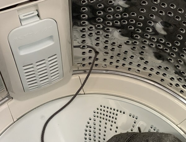 洗濯機の中の穴に紐が入った